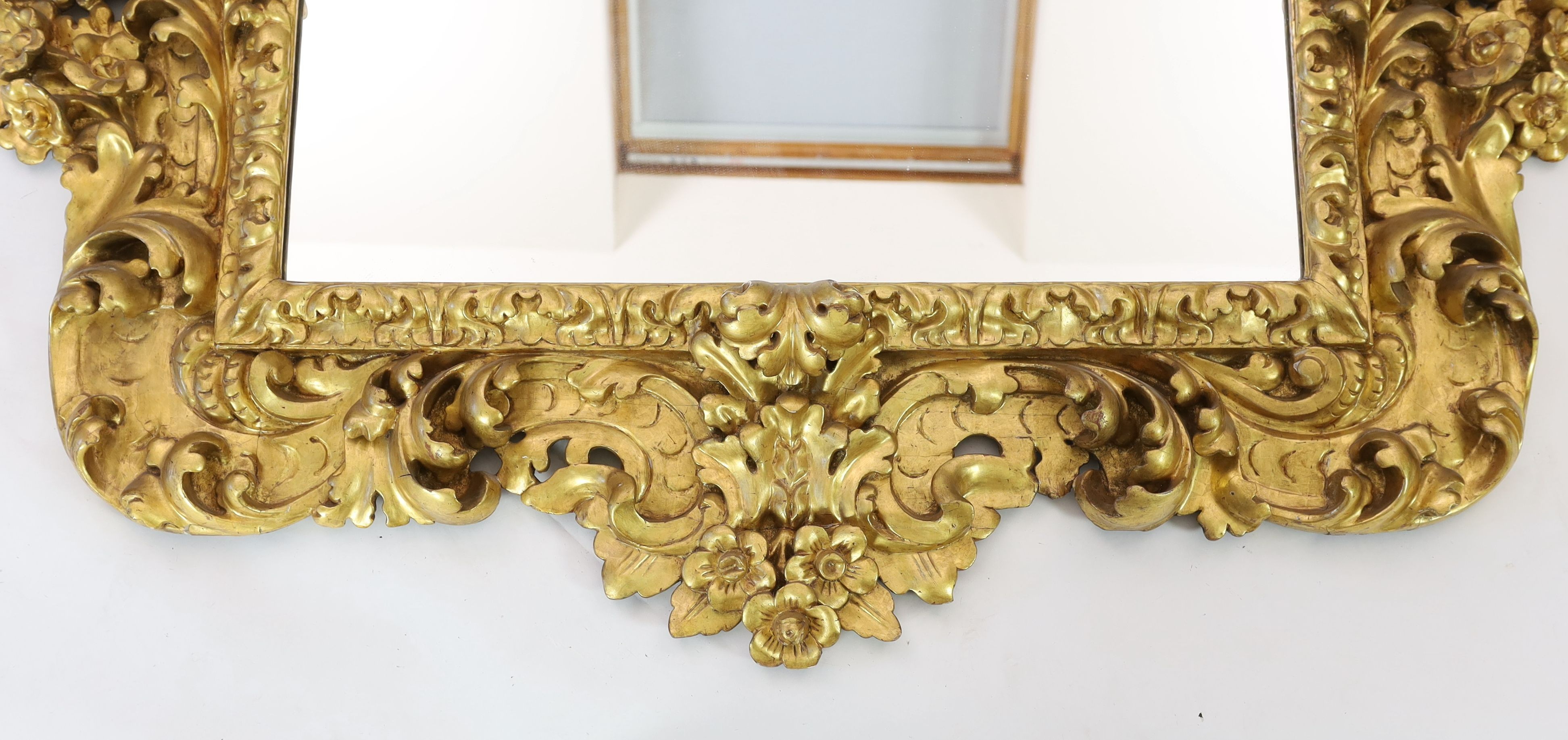 A mid 19th century Florentine ornately carved giltwood wall mirror, W.166cm H.158cm